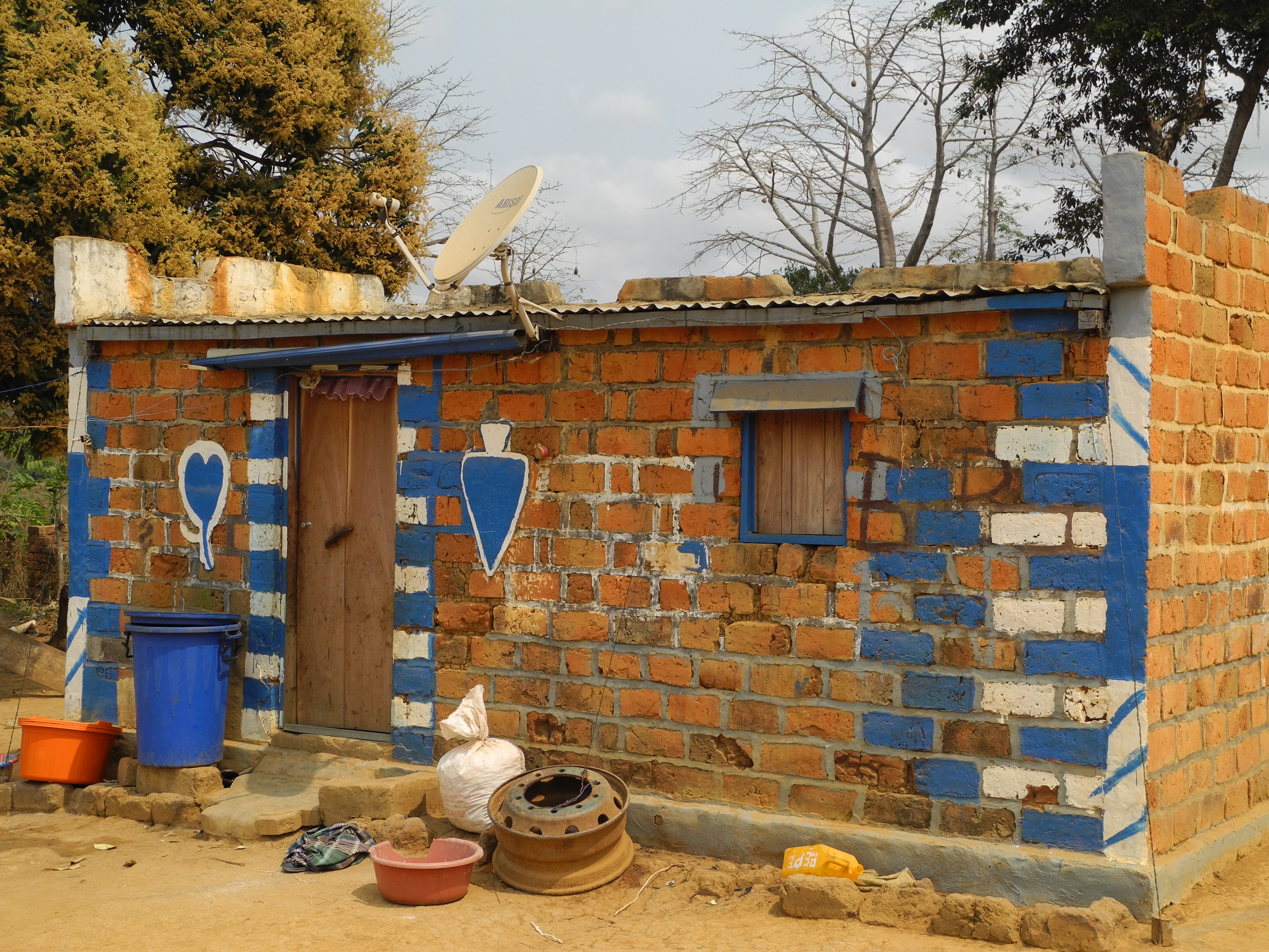 A small house painted blue and white with a corrugated iron roof 
