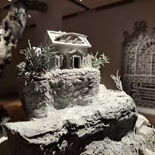 sculpture showing a small house on a cliff in the galllery