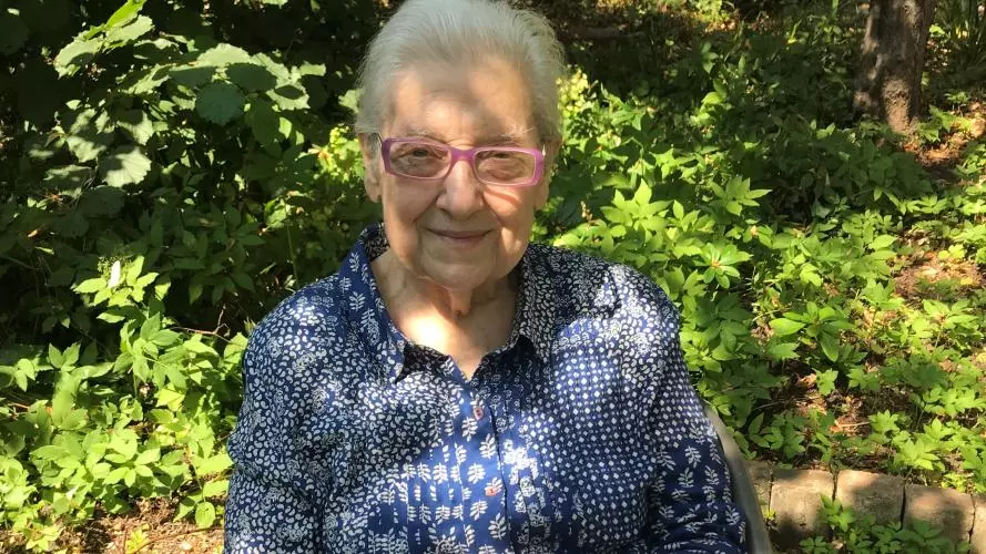 lidia sciama - an older woman sitting in a sunny garden
