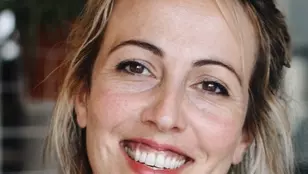 Dr Alex Alvergne is smiling at the camera with a wide smile. 