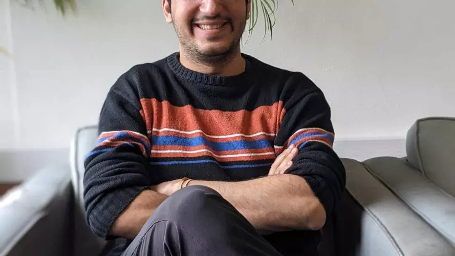 A man sitting in a grey chair smiling