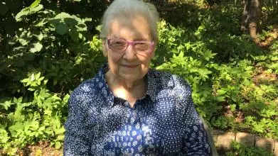 lidia sciama - an older woman sitting in a sunny garden