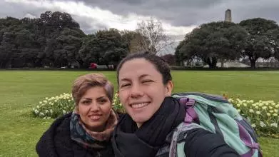 Selfie of two smiling women wrapped up in big coats on a grey day
