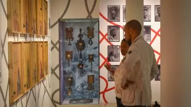 a man and a woman looking at exhibition together