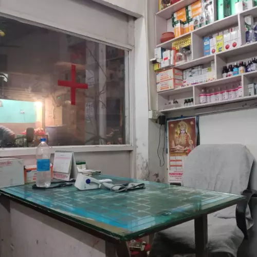 a makeshift office with a red cross on the window and medicines displayed behind the desk.
