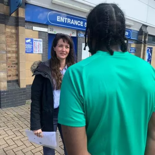 Woman talks to man outside prison