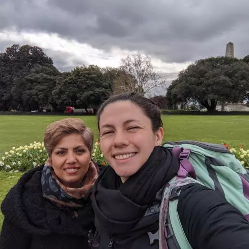 Selfie of two smiling women wrapped up in big coats on a grey day