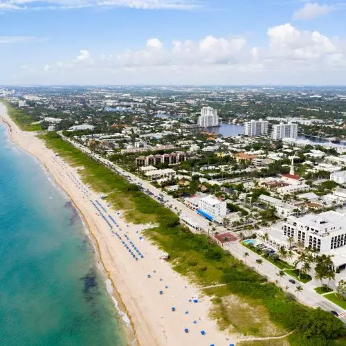 A view from above of Delray Beach, Florida; a long sandy beach next to an expansive town. 