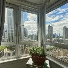 View from a living room's corner window showing sky scrapers and tower blocks on a sunny day