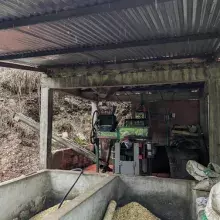 A roofed beneficiadero, where harvested coffee cherries are brought for processing, at the Bellavista farm, in a vereda (rural district) of the municipality of Arboledas, Norte de Santander. In the foreground are two cement fosas (basins); in the backgrou