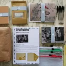Camera,s bags, postcards and instructions laid out on a table