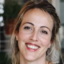 Dr Alex Alvergne is smiling at the camera with a wide smile. 