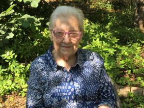 lidia sciama - an older woman sitting in a sunny garden