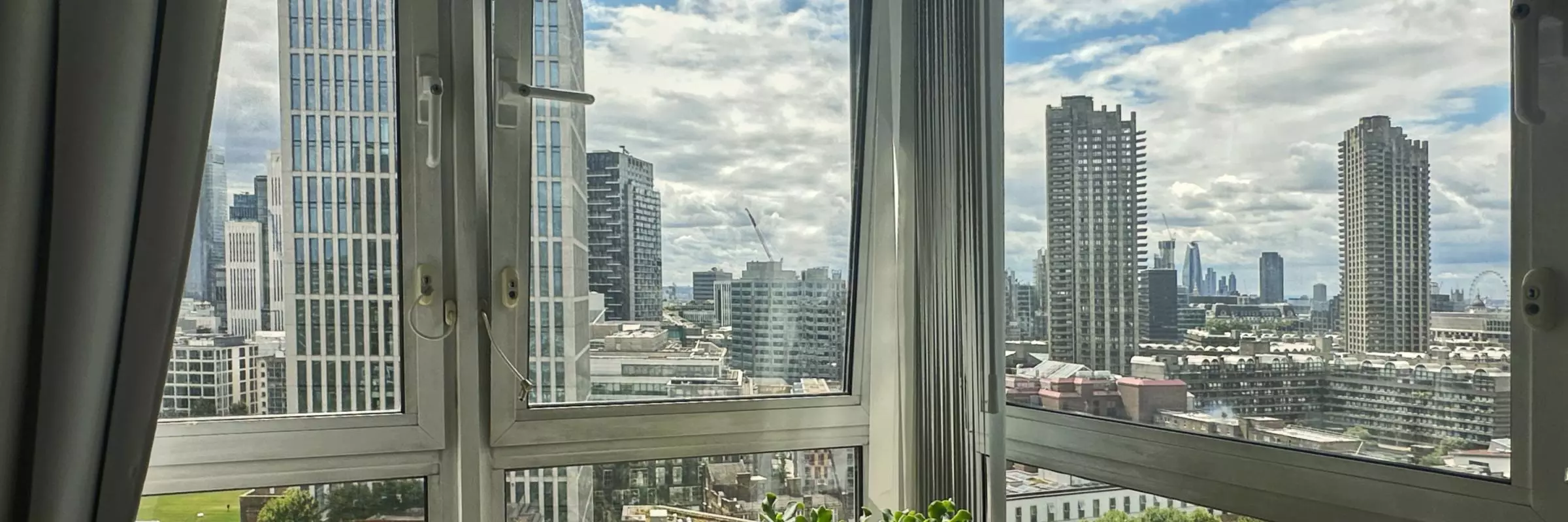 View from a living room's corner window showing an estate on a sunny day