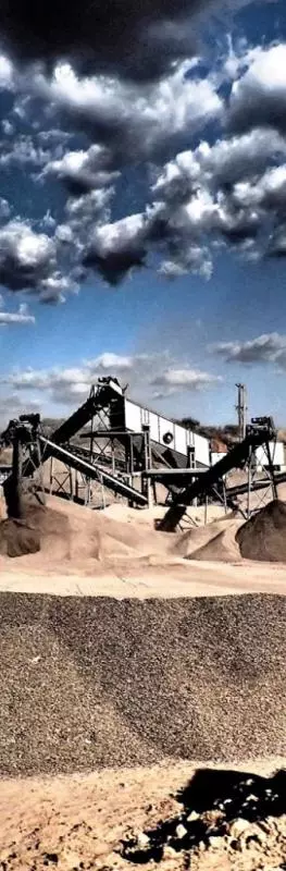 Gravel pit with machinery in sunny arid mountainous region