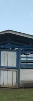 small wooden single story building painted blue and white