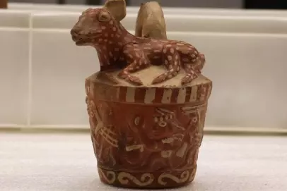 small clay pot with dear like animal on top