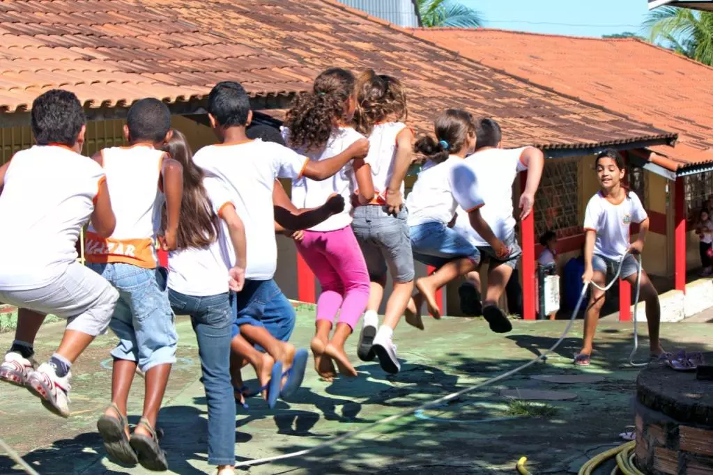 Children in a row jumping over a skipping rope
